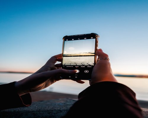 Smartphone and a glass of water on a desk capturing the evening transition